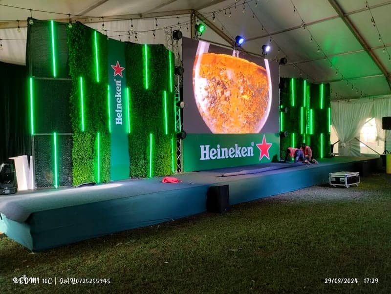 Cover of the Heineken Experience album: a green-hedge Heineken LED main stage with neon tubes and a beer-pour on screen