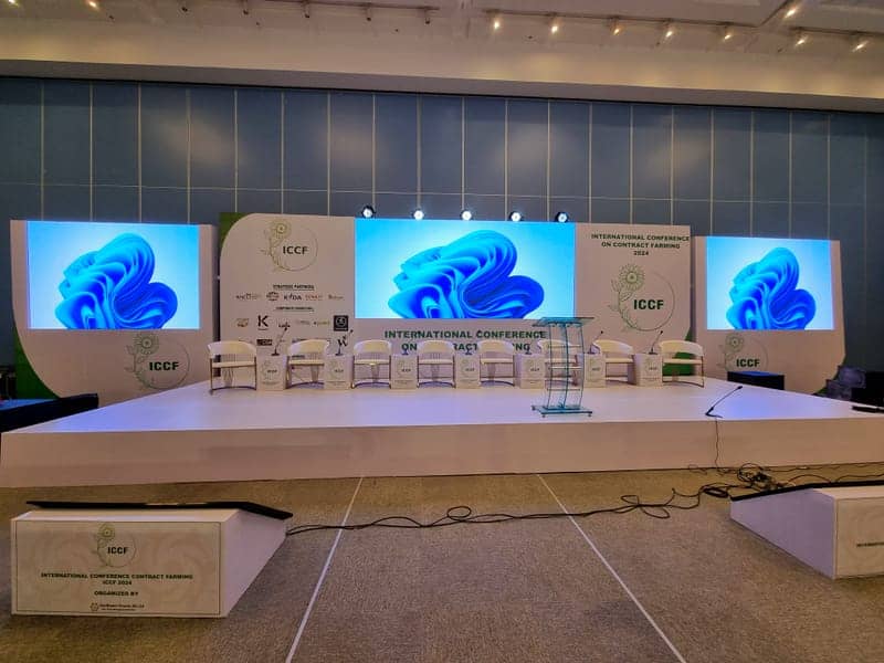 Cover of the ICCF 2024 album: an LED conference stage for the International Conference on Contract Farming with blue graphics