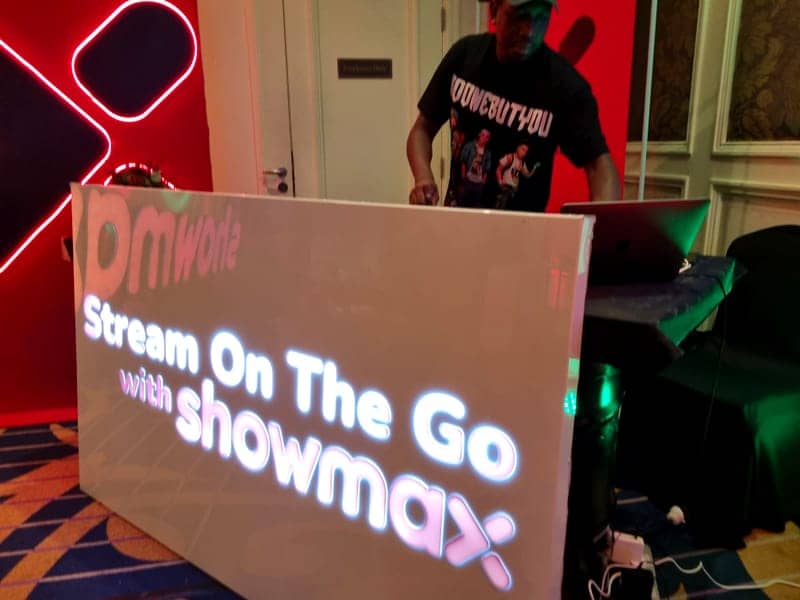 Cover of the Showmax album: a Stream On The Go with Showmax DJ booth with a neon X backdrop